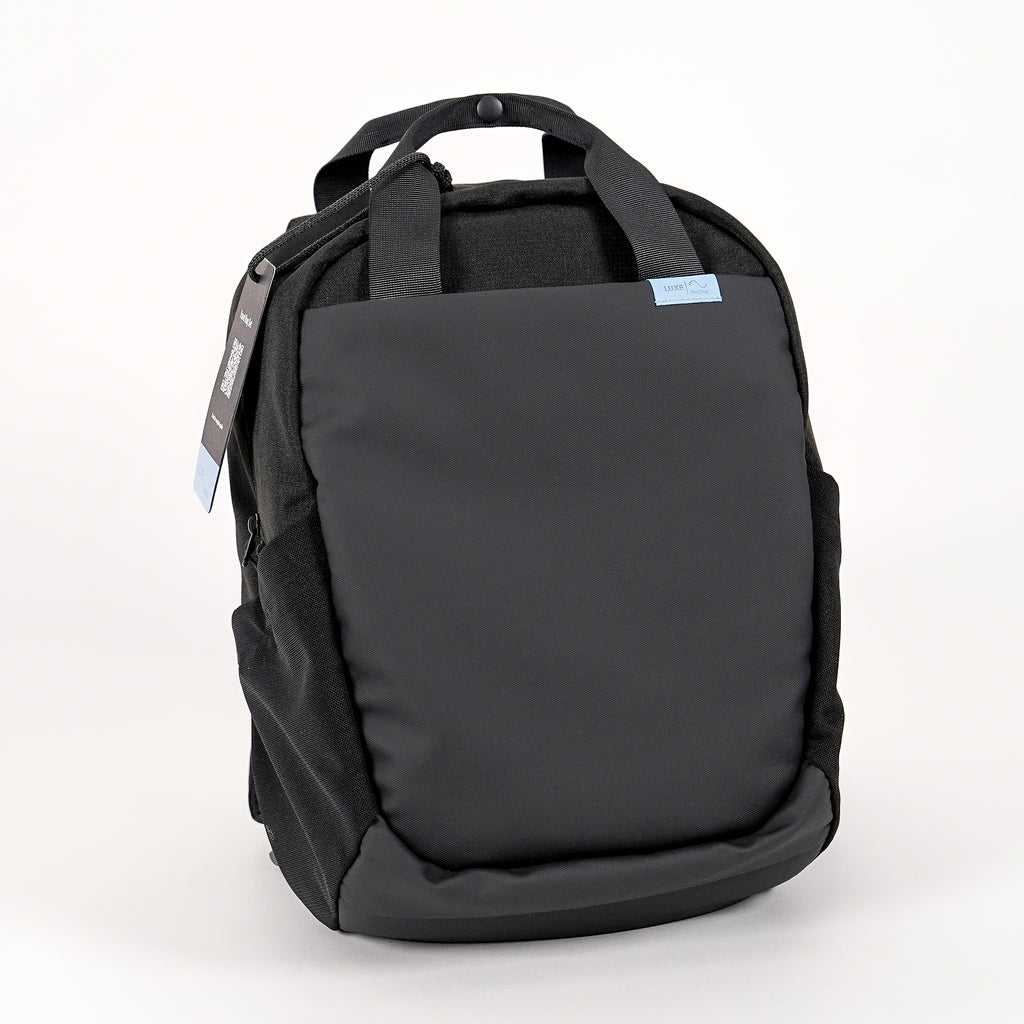  backpack in black facing front with a tag attached.