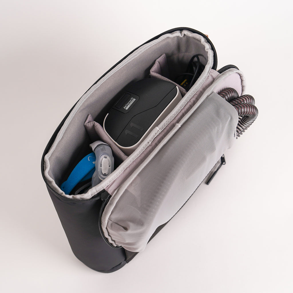 an open CPAP insert, on the lid there is the tubing. a CPAP machine, CPAP mask and power cord sits inside.