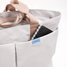 Zoom in of the grey totebag front pocket with notebook