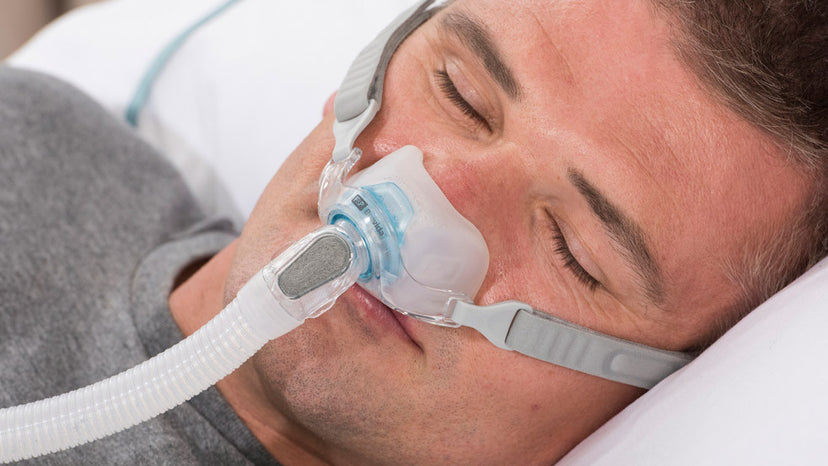 Man sleeping with CPAP therapy using Fisher and Paykel Brevida Nasal Pillow Mask